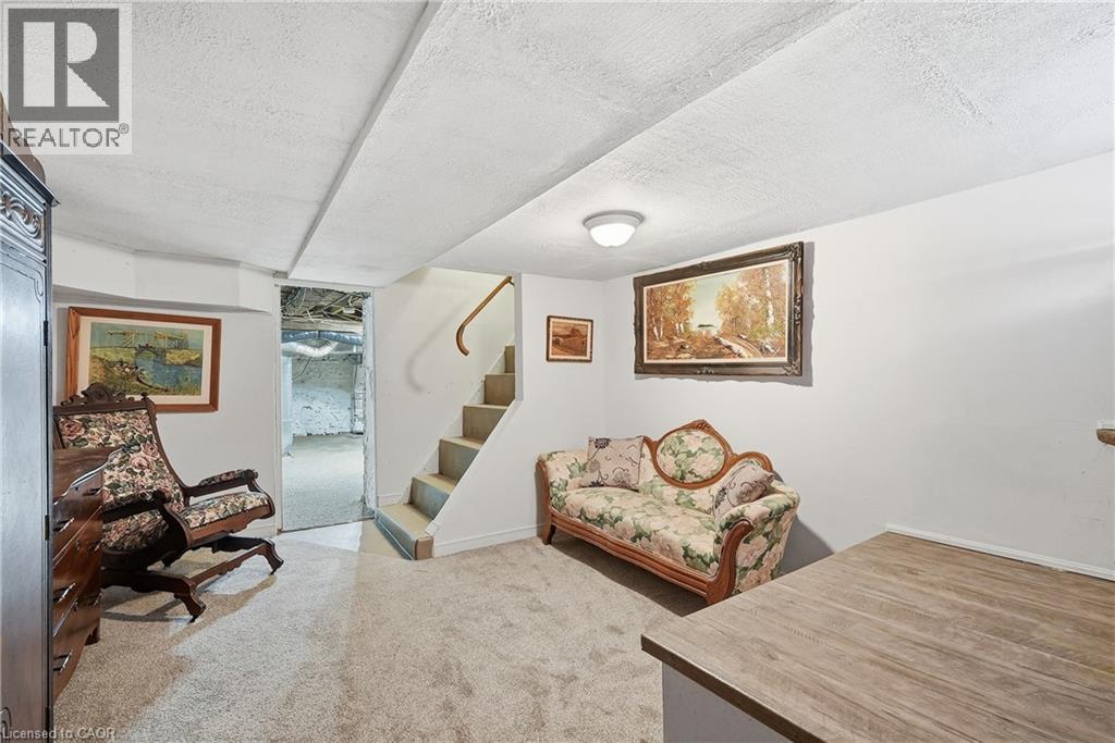 Finished lower level space featuring carpeted flooring and a built-in staircase with a wooden handrail - 153 Montrose Street N, Cambridge, ON - Indoor