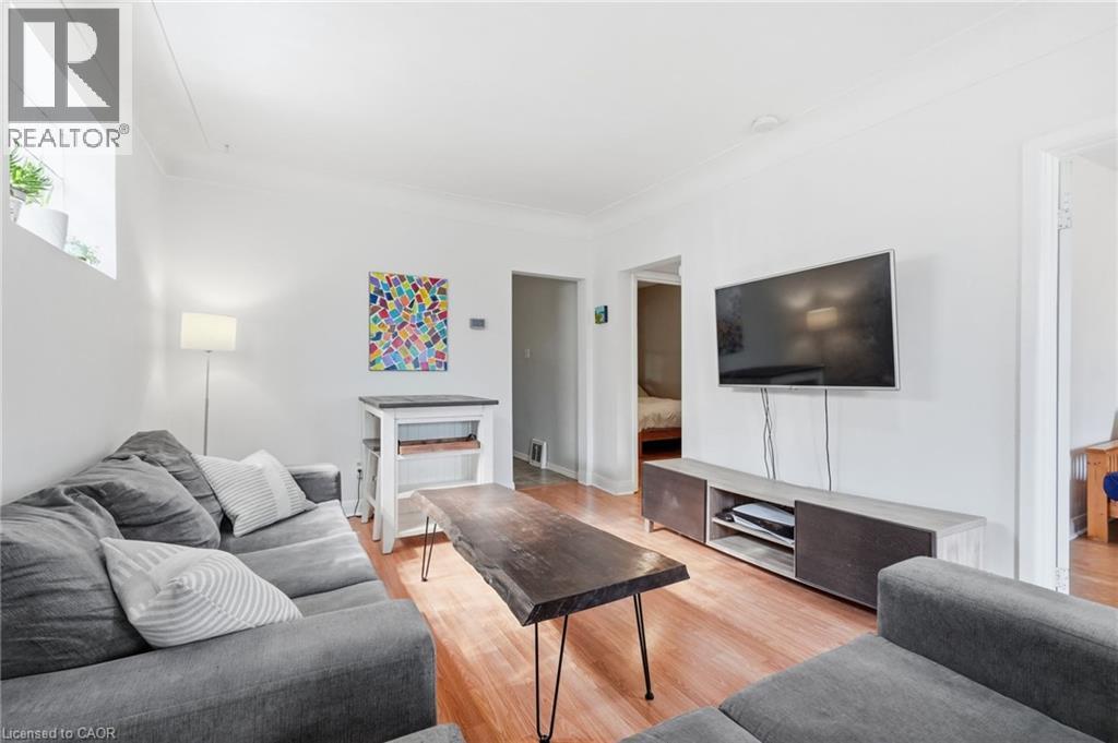 Living area featuring wood-finish flooring, white walls, and a recessed window - 58 Edinburgh Avenue, Hamilton, ON - Indoor Photo Showing Living Room