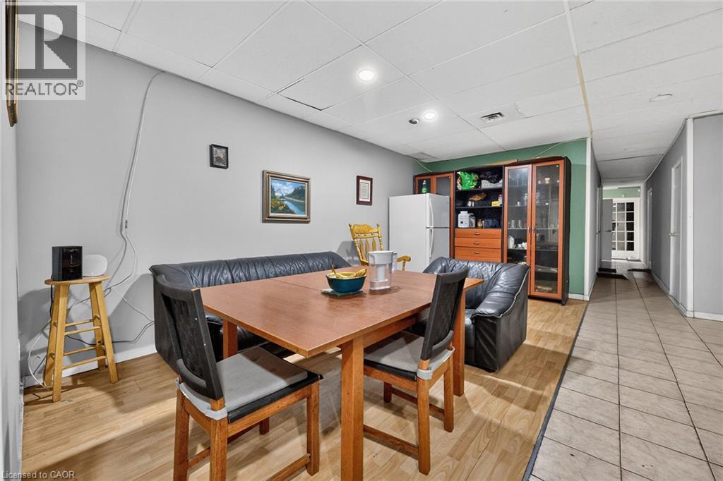 Open-concept area featuring wood-finish flooring in the dining space and tile flooring in the hallway - 1292 Barton Street E, Hamilton, ON