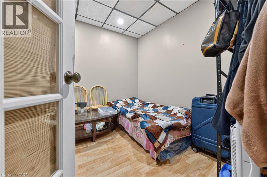 Room featuring wood-finish flooring, neutral wall paint, and a drop ceiling with recessed lighting - 1292 Barton Street E, Hamilton, ON