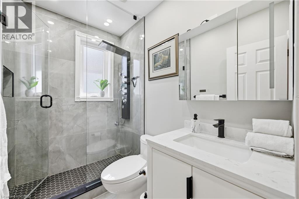 Bathroom featuring a glass-enclosed shower with gray tiled walls and hexagonal tile flooring - 18 Ipswich Place, Hamilton, ON - Indoor Photo Showing Bathroom