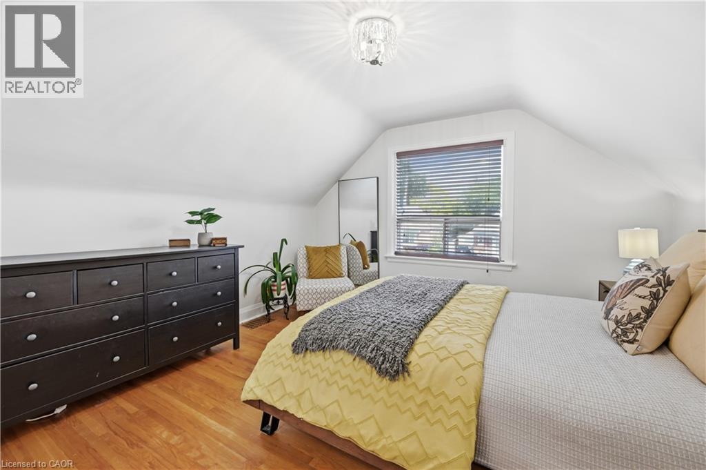 Room featuring hardwood flooring, sloped ceilings, and a window with blinds - 18 Ipswich Place, Hamilton, ON - Indoor Photo Showing Bedroom