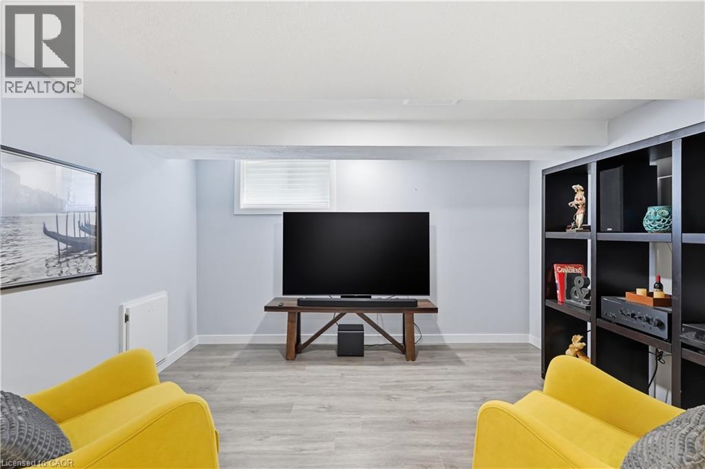 Finished lower level featuring light gray walls and wood-finish flooring - 18 Ipswich Place, Hamilton, ON - Indoor
