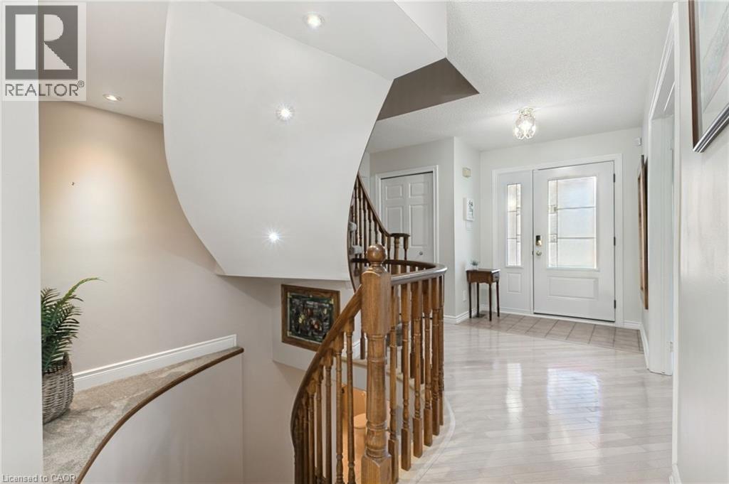 Foyer featuring light wood-finish flooring, an entry door with decorative glass inserts, and a chandelier - 2188 Bader Crescent, Burlington, ON - Indoor Photo Showing Other Room