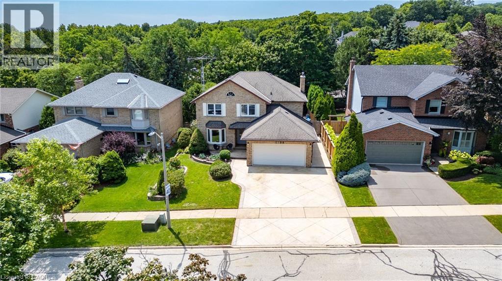 Traditional brick exterior featuring a multi-car driveway, attached garage, and landscaping - 2188 Bader Crescent, Burlington, ON - Outdoor With Facade