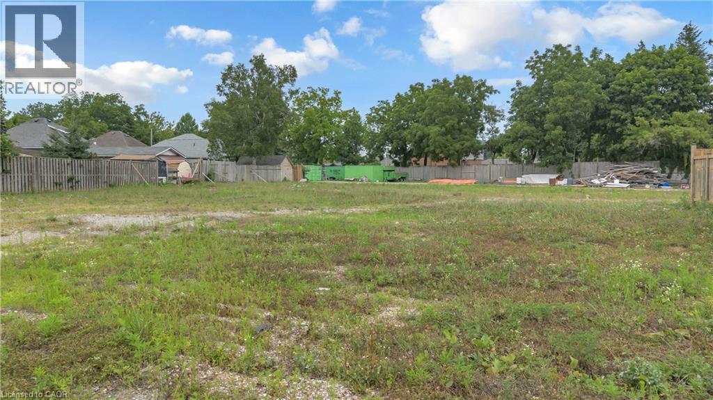 Expansive lot featuring a cleared, level terrain, partial fencing, and mature trees along the perimeter - 9 James Street, Simcoe, ON