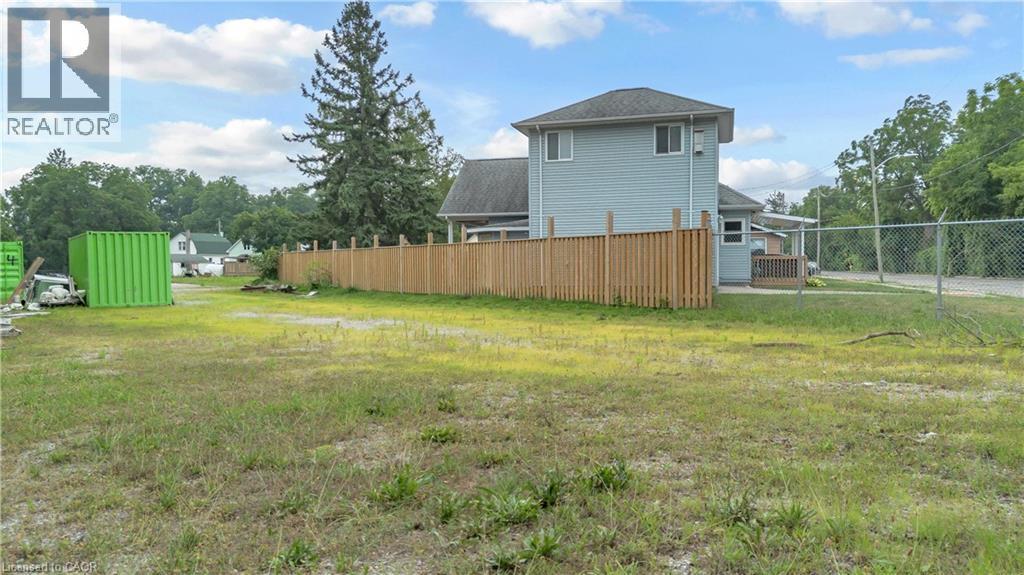 Spacious lot featuring a partial privacy fence, chain-link fencing, and mature trees on the perimeter - 9 James Street, Simcoe, ON