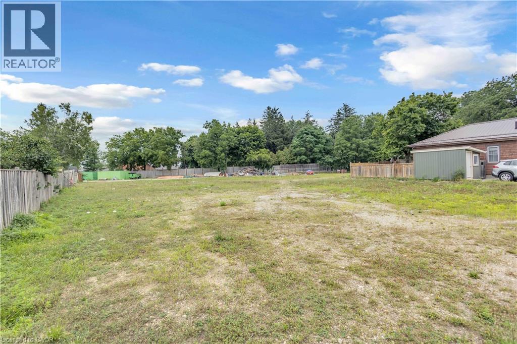 Spacious lot featuring perimeter fencing, mature trees, and a utility shed - 9 James Street, Simcoe, ON