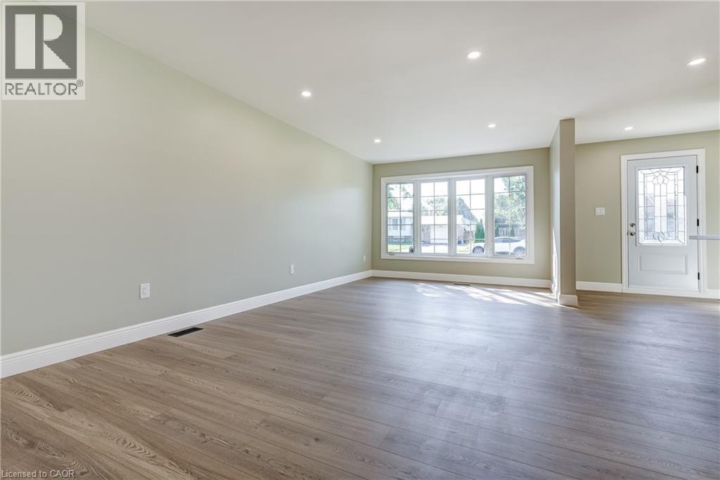 Spacious interior featuring wood-finish flooring, recessed lighting, and light-toned wall paint - 191 Glenmor Drive, Caledonia, ON - Indoor Photo Showing Other Room