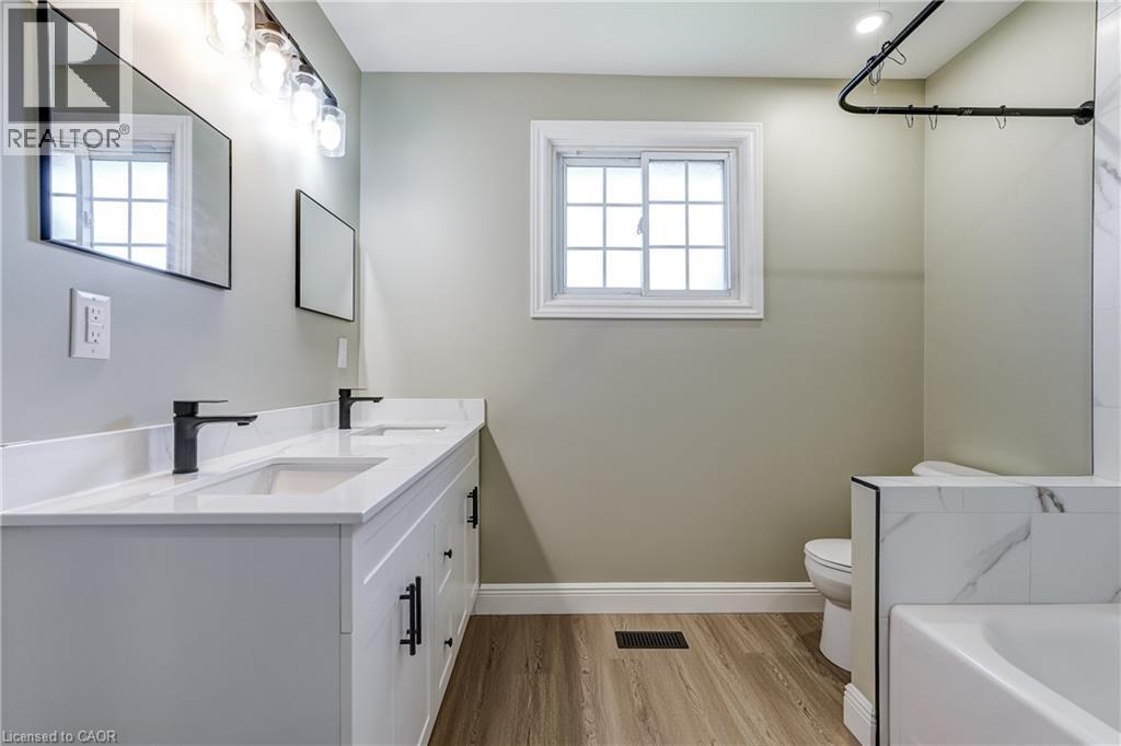 Bathroom featuring a double vanity with white cabinetry, white countertop, and matte black hardware - 191 Glenmor Drive, Caledonia, ON - Indoor Photo Showing Bathroom