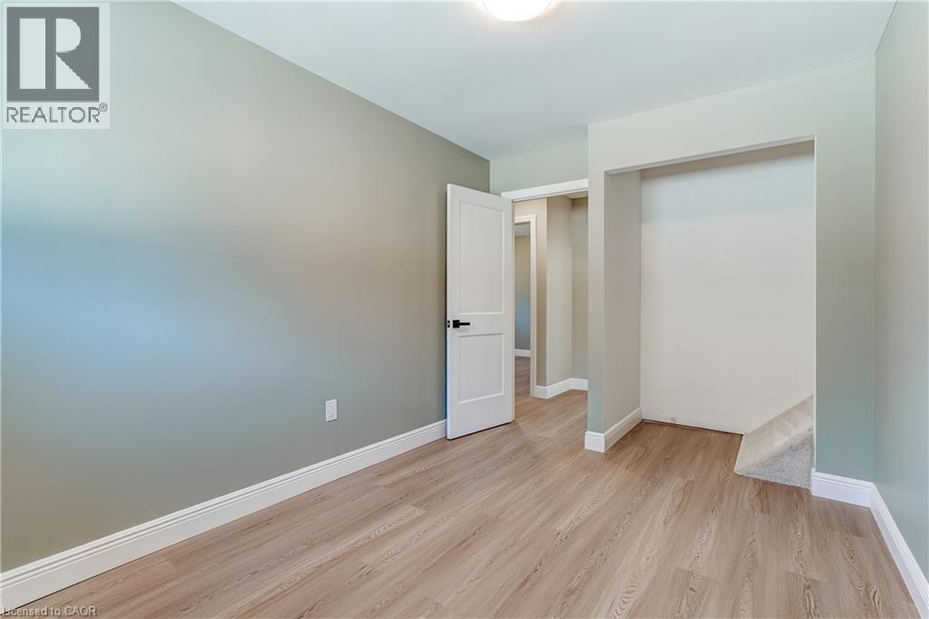 Interior room featuring light wood-finish flooring, light green wall paint, and white trim - 191 Glenmor Drive, Caledonia, ON - Indoor Photo Showing Other Room