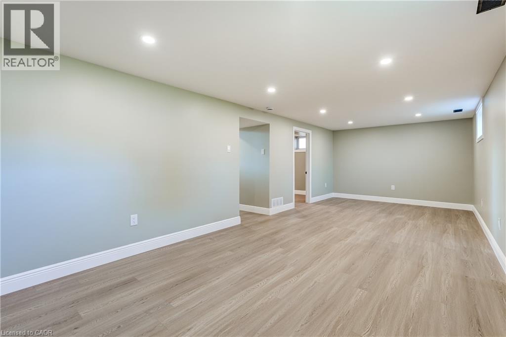 Spacious open area featuring recessed lighting, light wood-finish flooring, and light-toned walls with white baseboards - 191 Glenmor Drive, Caledonia, ON - Indoor