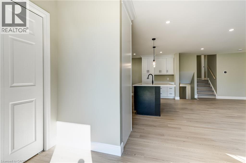 Open-concept living space featuring wood-finish flooring and light-toned walls - 191 Glenmor Drive, Caledonia, ON - Indoor