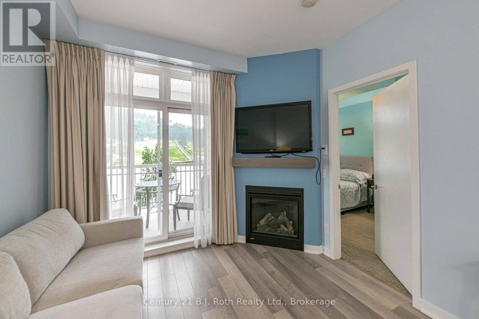 Walk out to balcony - Suite 206 - 40 Horseshoe Boulevard, Oro-Medonte (Horseshoe Valley), ON - Indoor Photo Showing Living Room With Fireplace