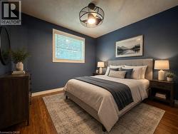 Room featuring wood-finish flooring, a contemporary ceiling fan, and a single window with blinds -