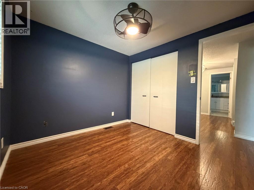 Room featuring wood-finish flooring, dark accent wall, and white trim - 41 Edgemere Drive, Cambridge, ON - Indoor Photo Showing Other Room