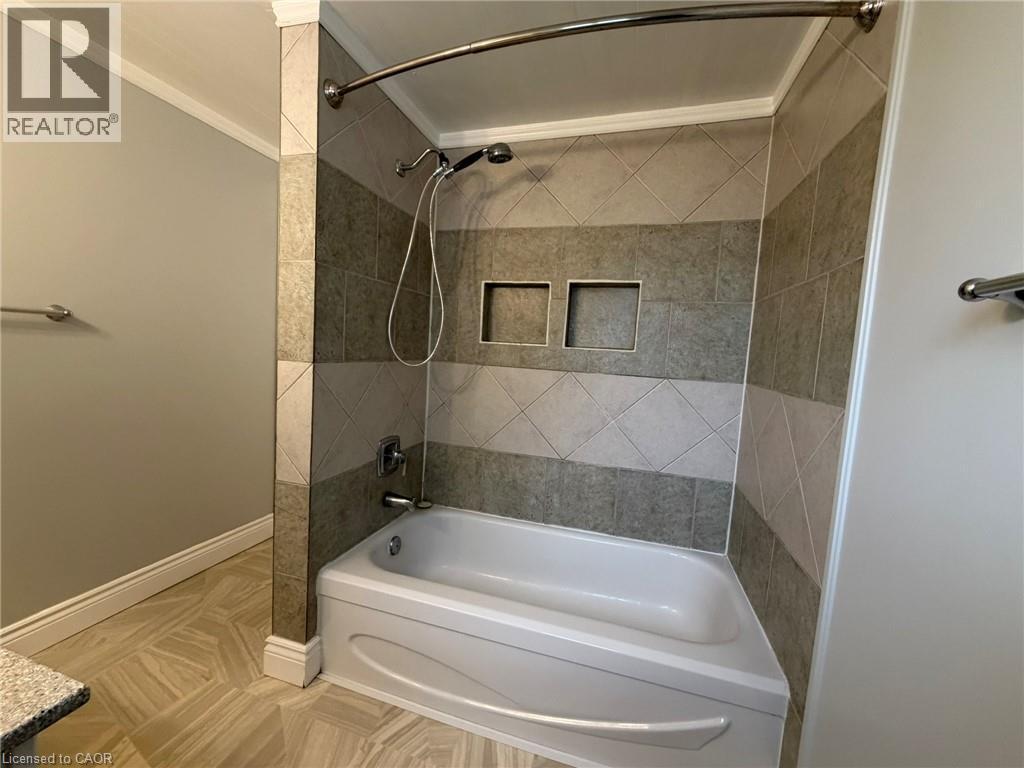 Bathtub and shower combination featuring a curved shower rod - 41 Edgemere Drive, Cambridge, ON - Indoor Photo Showing Bathroom