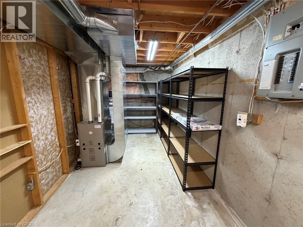 Unfinished basement space featuring a concrete floor, exposed ceiling joists, and a furnace unit - 41 Edgemere Drive, Cambridge, ON - Indoor Photo Showing Basement