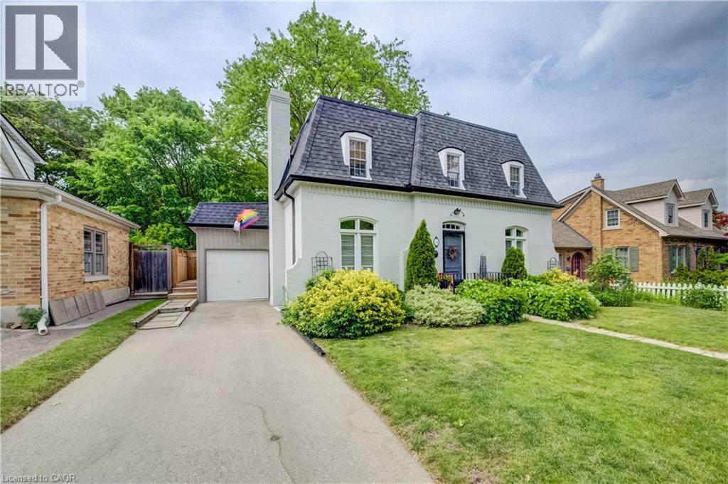 White stucco exterior with a dark gambrel roof, three dormer windows, and a prominent chimney - 314 Glasgow Street, Kitchener, ON - Outdoor