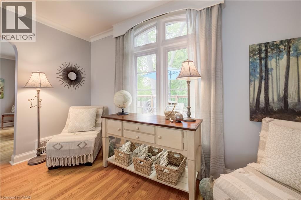 Hardwood flooring extends throughout this room, featuring a large multi-paned window with sheer and opaque drapery - 314 Glasgow Street, Kitchener, ON - Indoor Photo Showing Bedroom