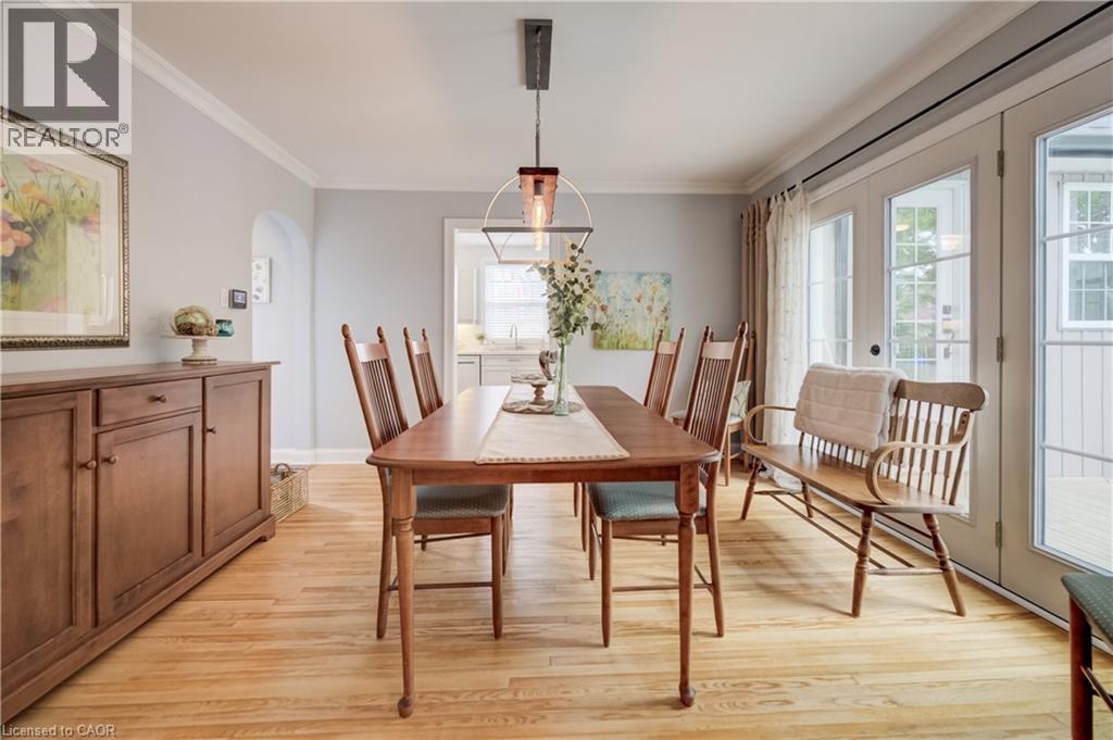 Dining area featuring wood-finish flooring, a contemporary linear pendant light, and crown molding - 314 Glasgow Street, Kitchener, ON - Indoor Photo Showing Dining Room