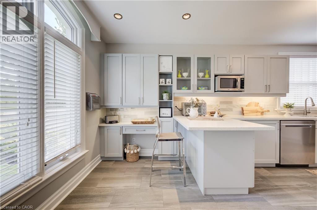 Modern kitchen featuring recessed lighting, light-toned cabinetry, and a central island with a solid surface countertop - 314 Glasgow Street, Kitchener, ON - Indoor Photo Showing Kitchen With Upgraded Kitchen