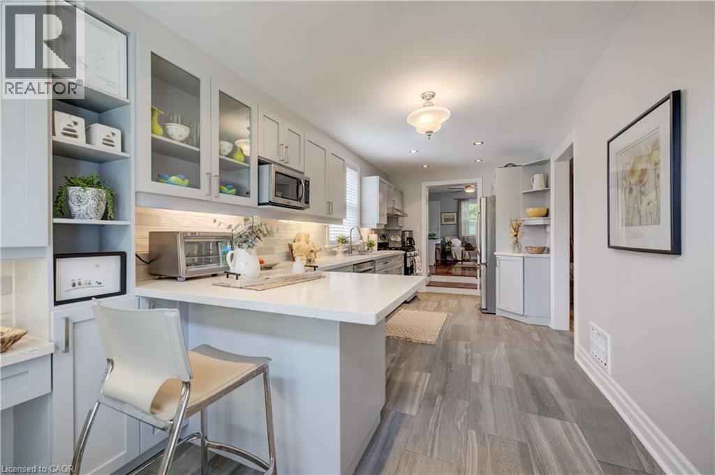 Contemporary kitchen featuring light gray cabinetry, quartz countertops, a tile backsplash, and wood-finish flooring - 314 Glasgow Street, Kitchener, ON - Indoor Photo Showing Kitchen