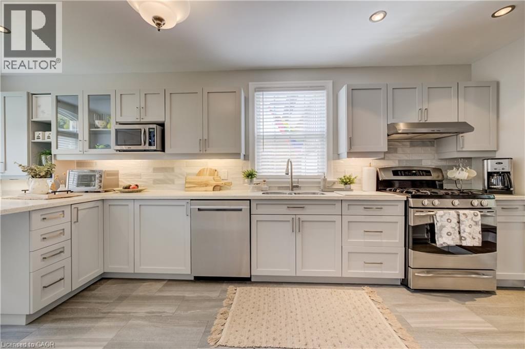Contemporary kitchen featuring light gray cabinetry, stainless steel appliances, a white subway tile backsplash, and light-toned countertops - 314 Glasgow Street, Kitchener, ON - Indoor Photo Showing Kitchen With Upgraded Kitchen
