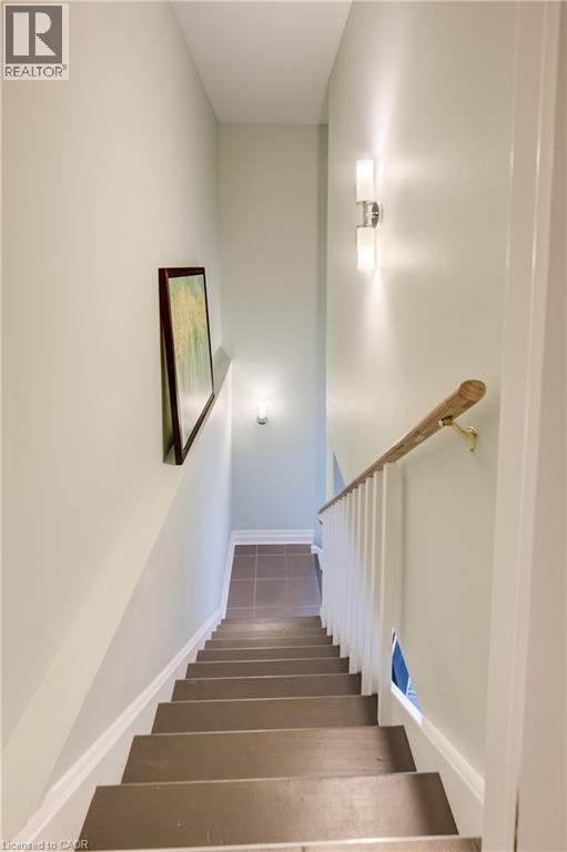 Staircase featuring wood treads, white risers, and a natural wood handrail with white balusters - 314 Glasgow Street, Kitchener, ON - Indoor Photo Showing Other Room