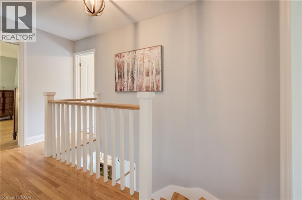 Upper-level landing featuring hardwood flooring and a white wooden staircase with a natural wood handrail - 314 Glasgow Street, Kitchener, ON - Indoor Photo Showing Other Room