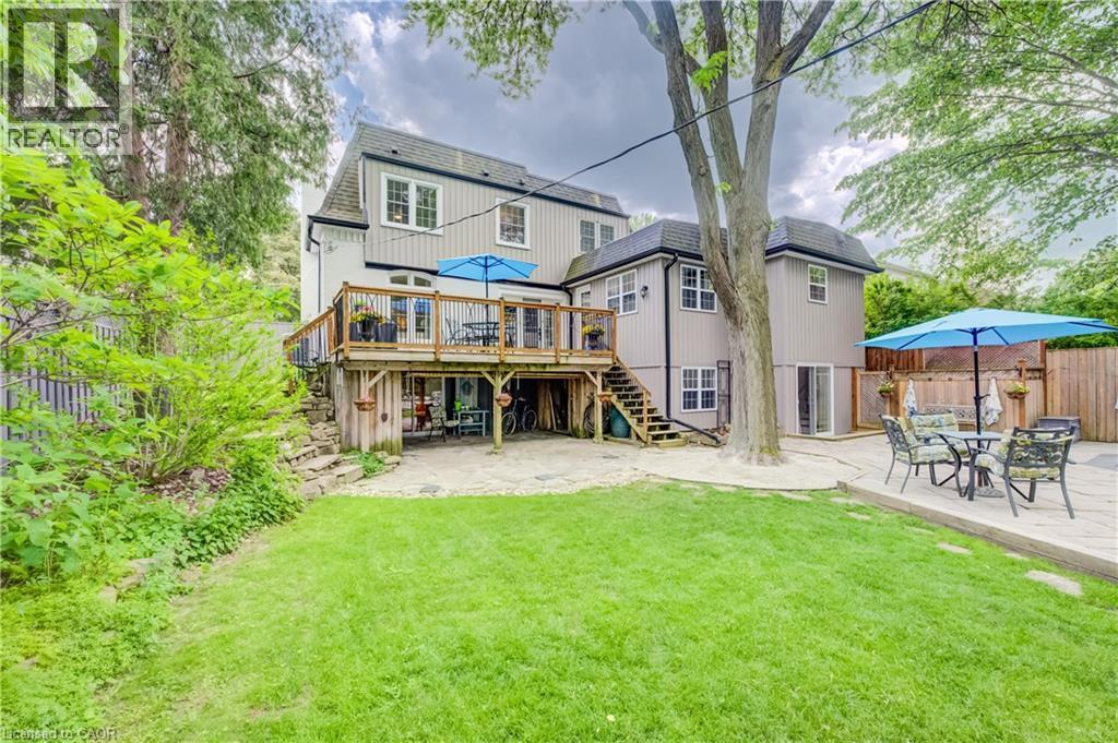 Rear exterior featuring a multi-level deck, ground-level patio, and a manicured lawn - 314 Glasgow Street, Kitchener, ON - Outdoor With Deck Patio Veranda