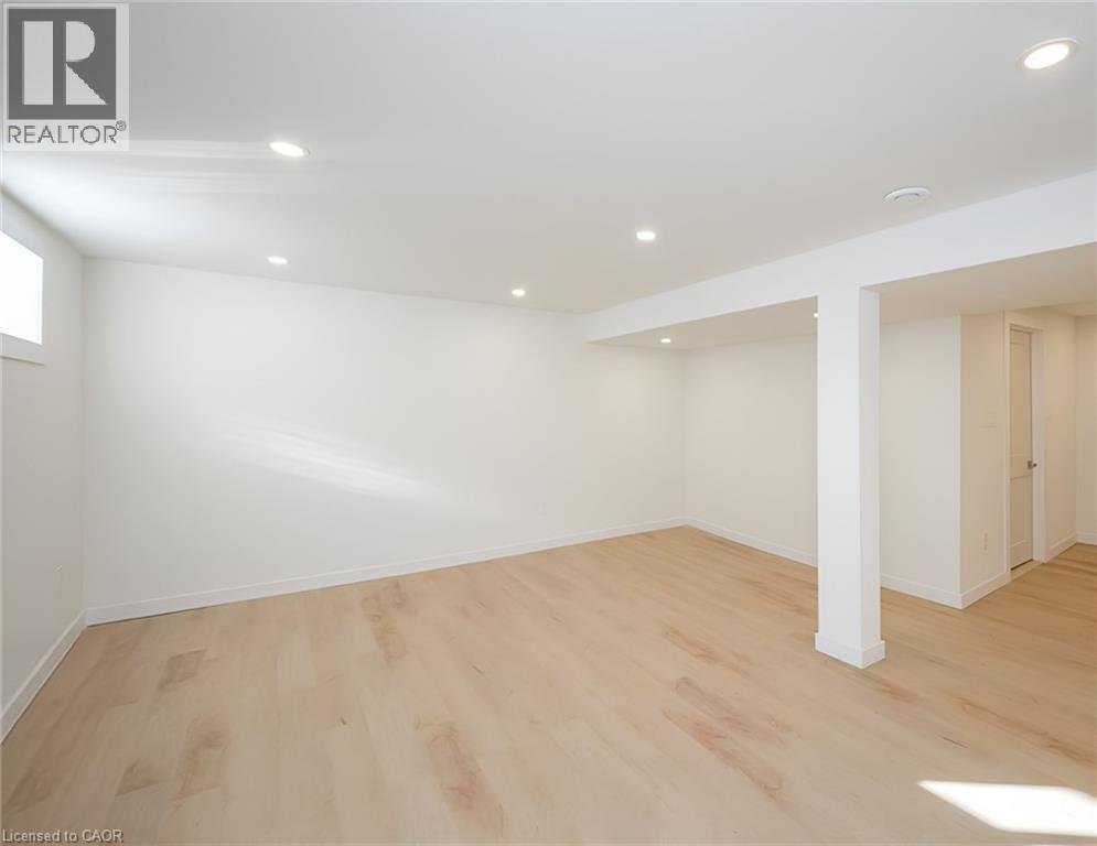 Spacious living area featuring light wood-finish flooring, recessed ceiling lighting, and a neutral color palette - 781 Ninth Avenue Unit# Lower, Hamilton, ON - Indoor Photo Showing Other Room