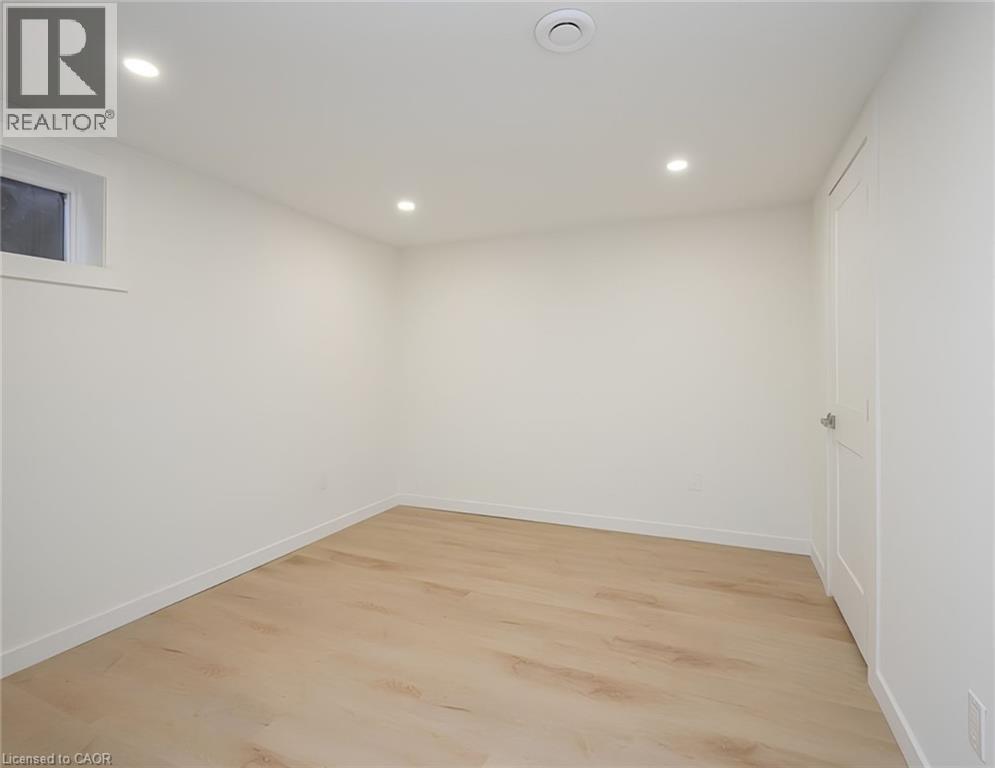 Bedroom featuring light-tone wood-finish flooring, recessed lighting, and a white paneled door - 781 Ninth Avenue Unit# Lower, Hamilton, ON - Indoor Photo Showing Other Room