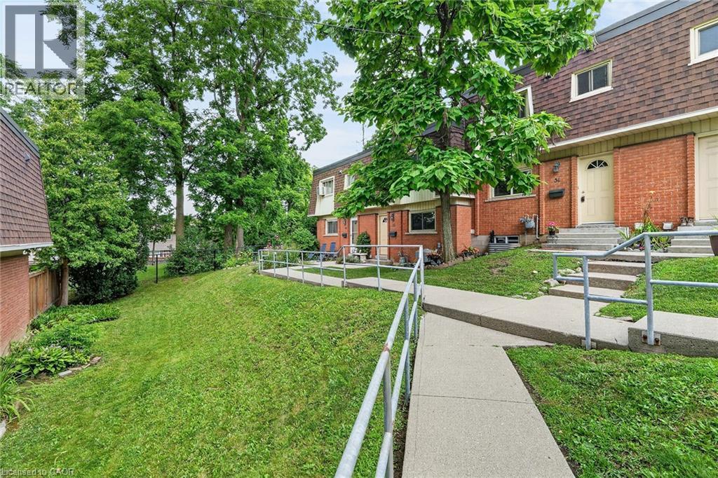 Brick exterior townhome with a gambrel roof and dormer windows - 125 Bonaventure Drive Unit# 50, Hamilton, ON - Outdoor With Exterior