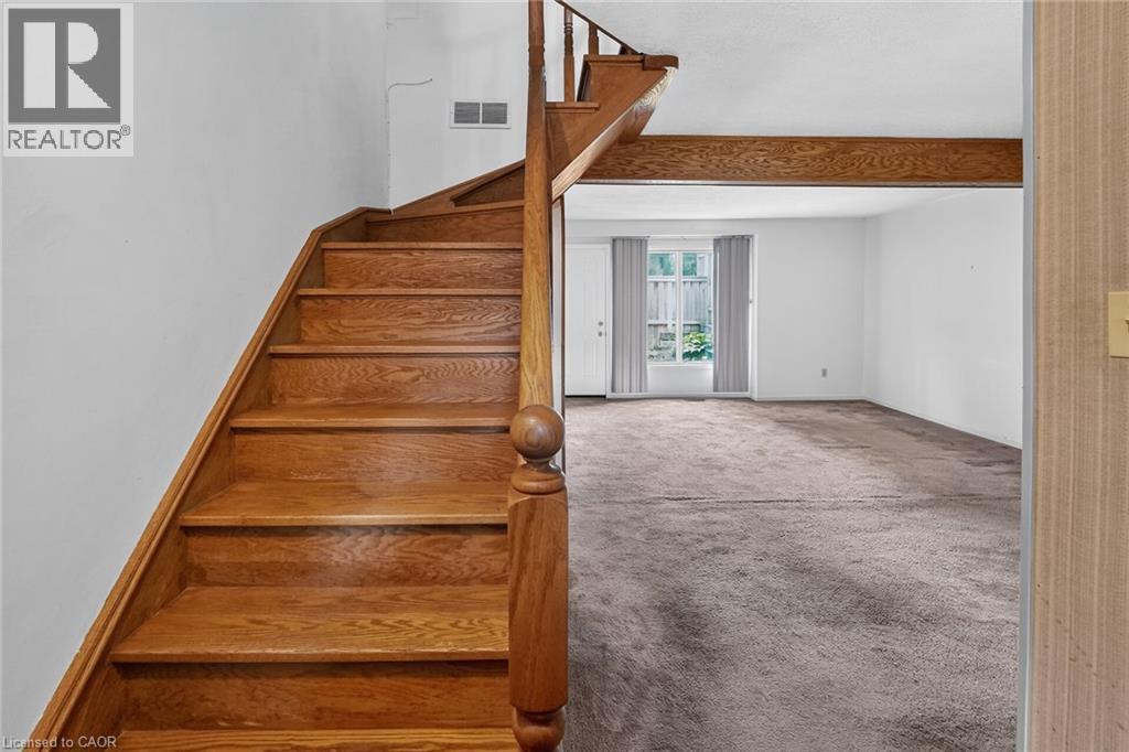 Hardwood staircase with turned newel post and balustrade - 125 Bonaventure Drive Unit# 50, Hamilton, ON - Indoor Photo Showing Other Room