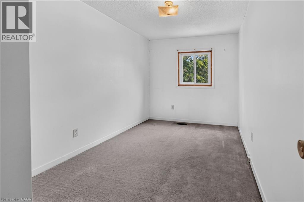 Neutral white walls complement the gray carpeting in this room - 125 Bonaventure Drive Unit# 50, Hamilton, ON - Indoor Photo Showing Other Room