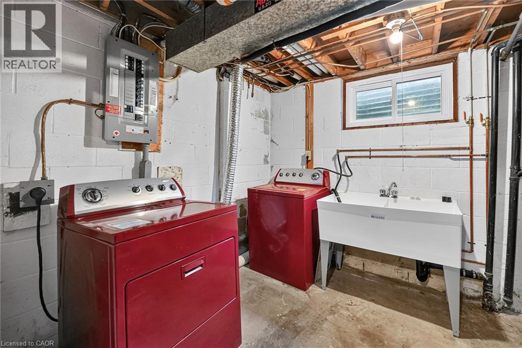 Dedicated laundry area featuring a utility sink, exposed ceiling joists, and a window - 125 Bonaventure Drive Unit# 50, Hamilton, ON - Indoor Photo Showing Laundry Room