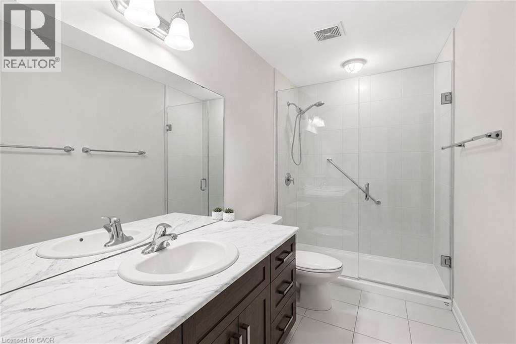 Bathroom vanity with dual undermount sinks and a marble-finish countertop - 133 St Leger Street, Kitchener, ON - Indoor Photo Showing Bathroom