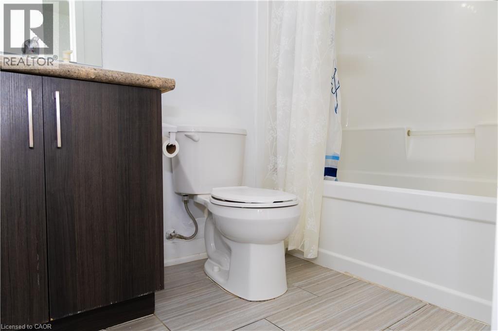 Bathroom vanity with dark wood-finish cabinetry and a light-toned countertop - 190 Century Hill Drive Unit# A5, Kitchener, ON - Indoor Photo Showing Bathroom