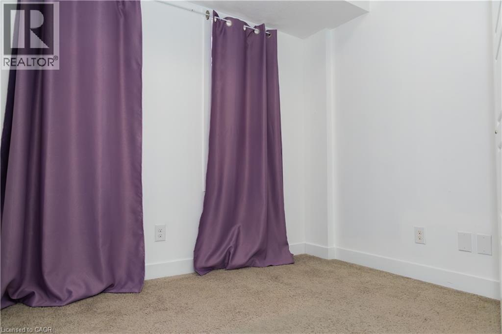 Carpeted room with white walls, baseboards, and two electrical outlets - 190 Century Hill Drive Unit# A5, Kitchener, ON - Indoor