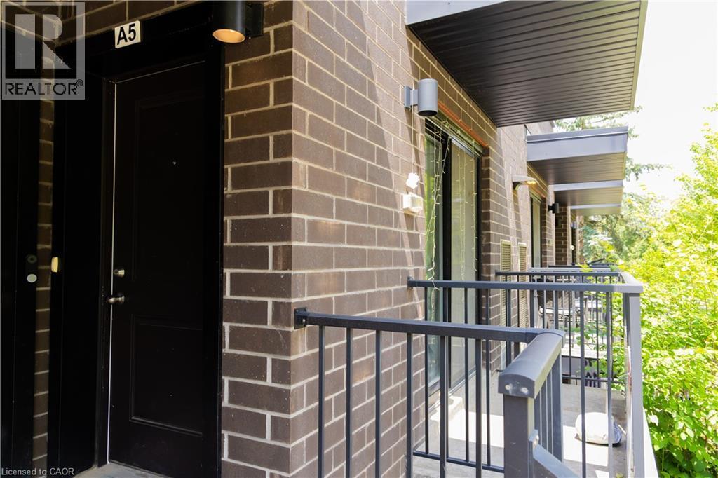 Exterior brick facade featuring a private balcony with black metal railings - 190 Century Hill Drive Unit# A5, Kitchener, ON - Outdoor With Exterior