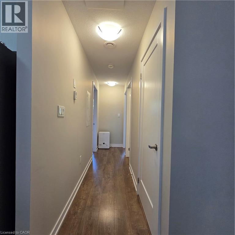 Hallway featuring wood-finish flooring, light neutral wall paint, and white trim - 20 Palace Place Unit# E9, Kitchener, ON - Indoor Photo Showing Other Room