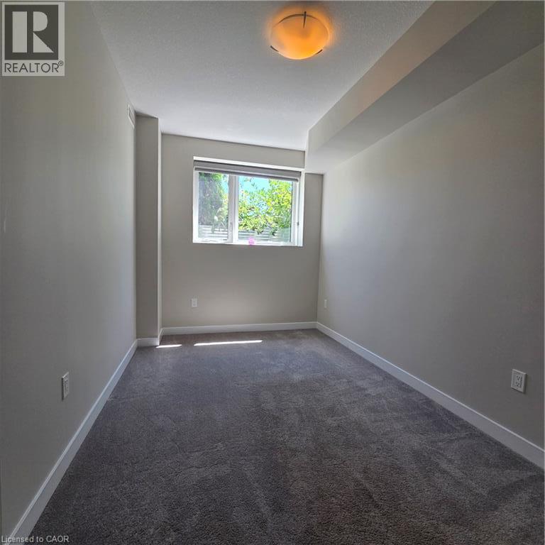 Bedroom featuring neutral wall paint, gray carpeting, and a window with blinds - 20 Palace Place Unit# E9, Kitchener, ON - Indoor Photo Showing Other Room