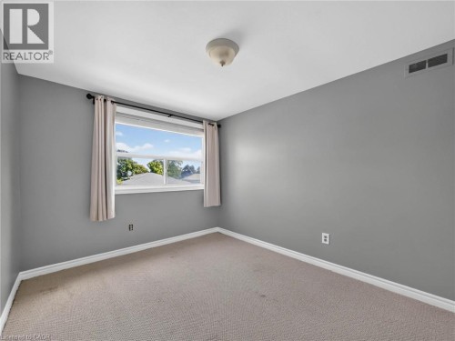 Room with neutral gray walls, white trim, and light beige carpet - 143 Cromwell Crescent, Hamilton, ON - Indoor Photo Showing Other Room