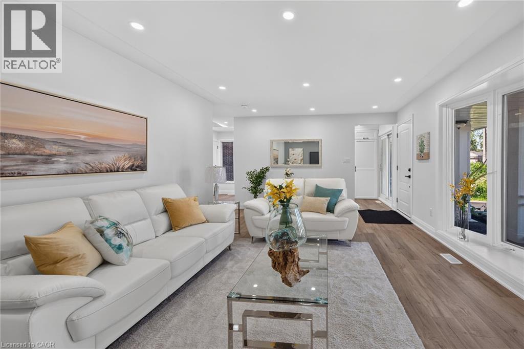 Spacious living area featuring recessed lighting, large picture windows, wood-finish flooring, and a white interior color palette - 101 Loyalist Drive, Hamilton, ON - Indoor Photo Showing Living Room