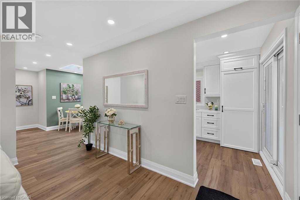 Wood-finish flooring extending throughout, recessed lighting, white baseboards, and light gray wall tones - 101 Loyalist Drive, Hamilton, ON - Indoor Photo Showing Other Room