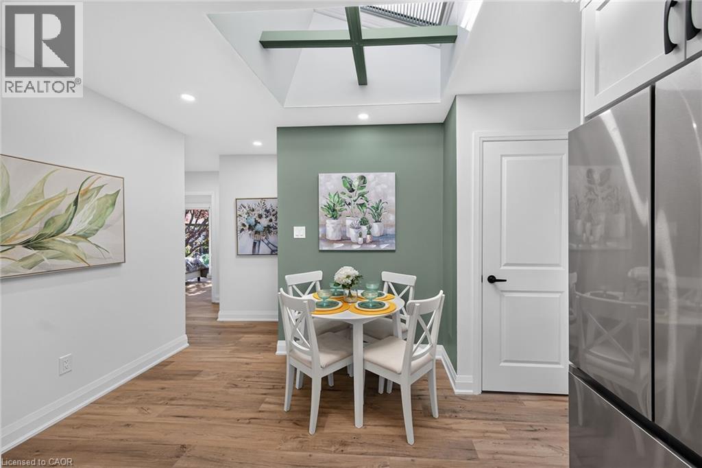 Dining area featuring a skylight with exposed beams, wood-finish flooring, recessed lighting, and a contrasting accent wall - 101 Loyalist Drive, Hamilton, ON - Indoor Photo Showing Other Room