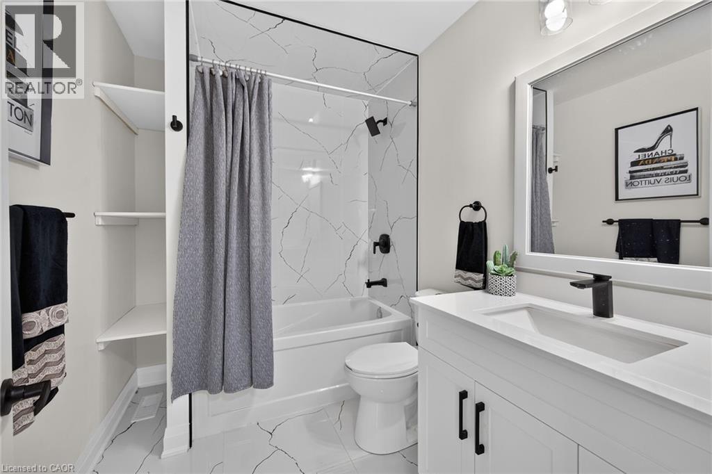Bathroom featuring a white vanity with a quartz-finish countertop and integrated sink - 101 Loyalist Drive, Hamilton, ON - Indoor Photo Showing Bathroom