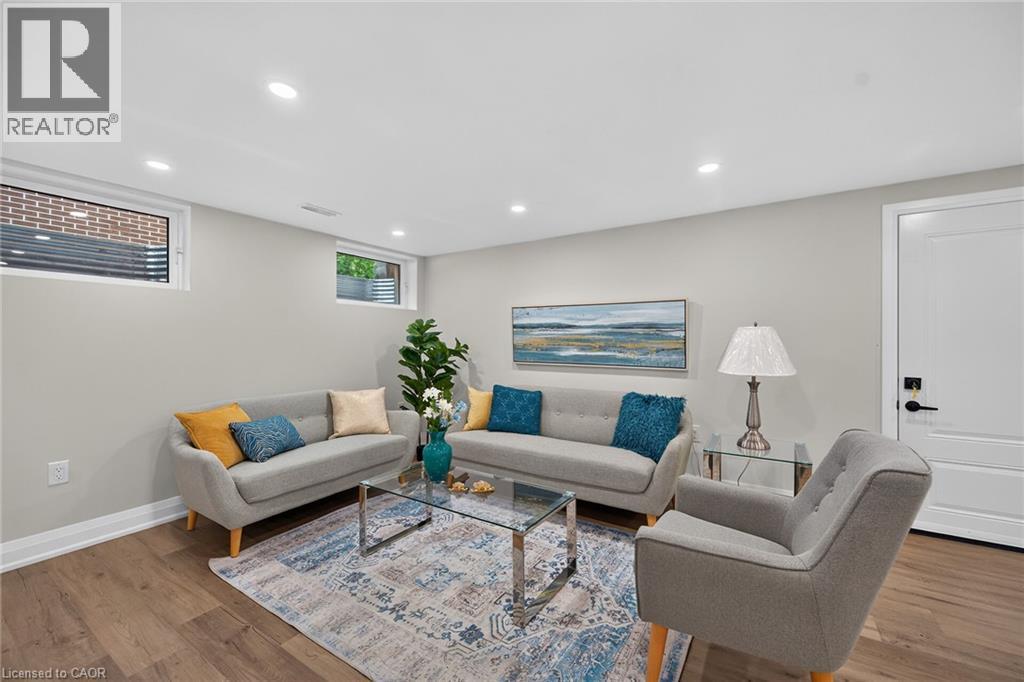 Spacious living area featuring recessed lighting, light gray walls, wood-finish flooring, and white trim - 101 Loyalist Drive, Hamilton, ON - Indoor