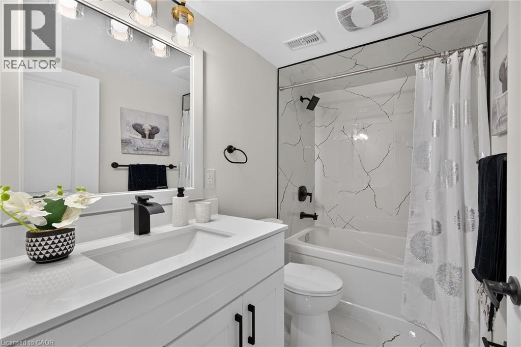 Modern bathroom featuring a white vanity with integrated sink, black matte faucet, and matching hardware - 101 Loyalist Drive, Hamilton, ON - Indoor Photo Showing Bathroom